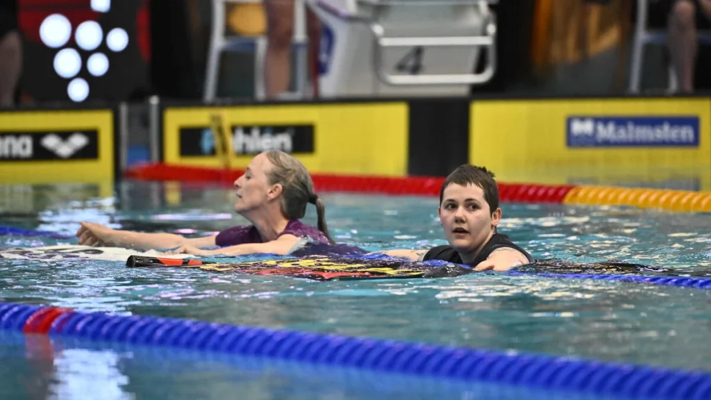 Klimataktivister hoppar i bassängen före Sjöströms Swim Open-final